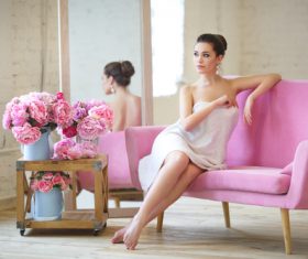 Stock Photo Woman wearing bath towel sitting on sofa