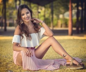 Stock Photo Woman with tattoo on leg sitting on the grass
