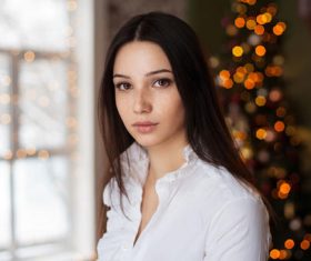 Stock Photo Young girl with christmas tree behind
