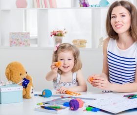 Stock Photo Young mom and daughter holding plasticine