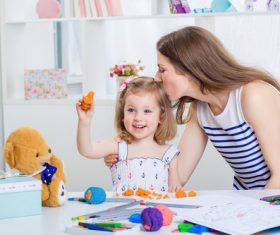 Stock Photo Young mom kisses daughter