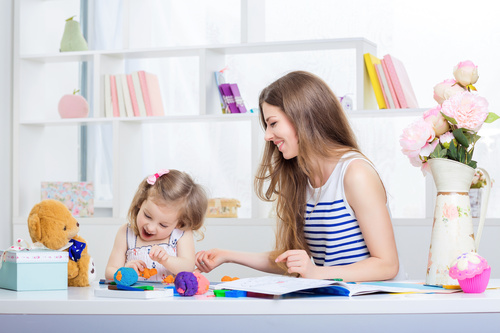 Stock Photo Young mother teasing daughter laughing