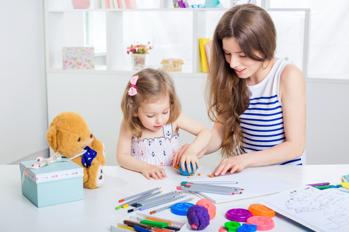 Stock Photo Young mother with her daughter playing with plasticine