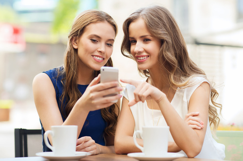 Two women looking at the phone Stock Photo