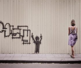 Woman looking at graffiti on the wall Stock Photo