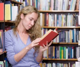 Woman reading book in the library Stock Photo