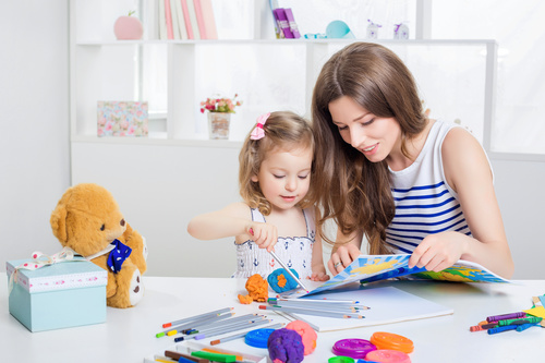 Young mother and daughter coloring picture book with colored pencils Stock Photo 05