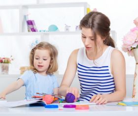 Young mother and daughter coloring picture book with colored pencils Stock Photo 04