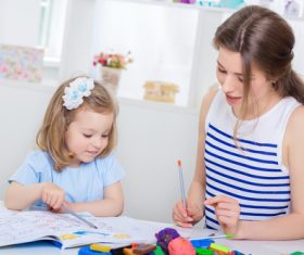 Young mother and daughter coloring picture book with colored pencils Stock Photo 01