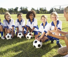 a group of students listening to football coach Stock Photo