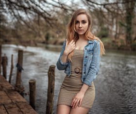 outdoors women wearing denim tight dress sitting by the river Stock Photo 01