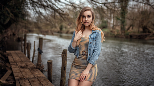 outdoors women wearing denim tight dress sitting by the river Stock Photo 01