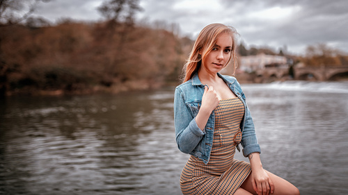 outdoors women wearing denim tight dress sitting by the river Stock Photo 02