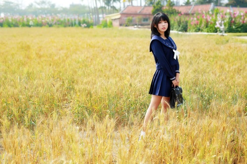 schoolgirl standing outdoors field Stock Photo