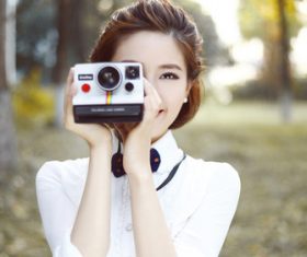 Asian woman holding camera taking photo Stock Photo