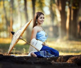 Beautiful Vietnamese woman outdoors with umbrella placed on the ground Stock Photo