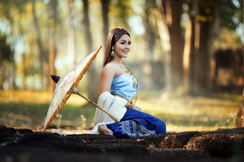 Beautiful Vietnamese woman outdoors with umbrella placed on the ground Stock Photo