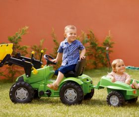 Brother driving toy car carrying sister Stock Photo