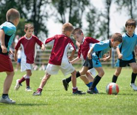 Children playing football on the grass Stock Photo