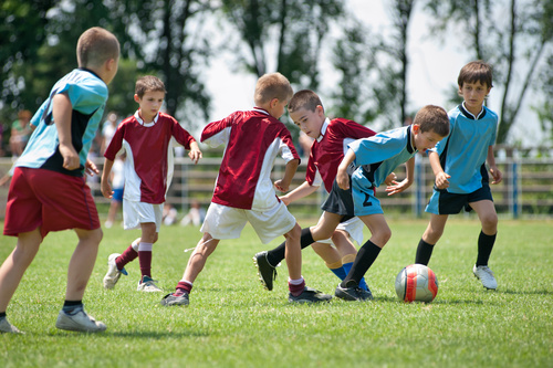 Children playing football on the grass Stock Photo