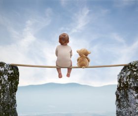 Creative photo little baby sitting on wooden bridge Stock Photo