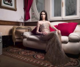 Elegant noble woman sitting on the couch Stock Photo