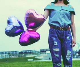 Girl holding three heart balloons Stock Photo
