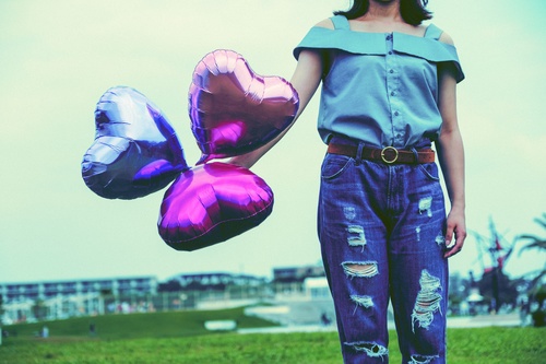 Girl holding three heart balloons Stock Photo