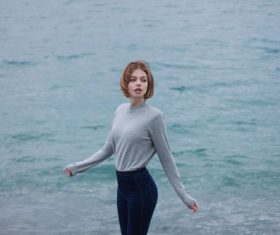 Girl in grey sweater stands by the river Stock Photo