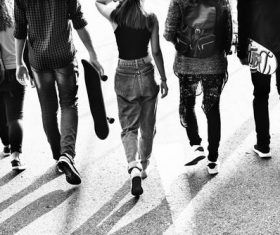 Grayscale photography of five young people walking on the road Stock Photo