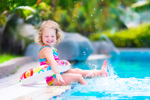 Happy children sitting by the pool Stock Photo