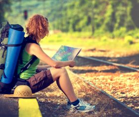Holding map sitting on the roadside to rest backpackers Stock Photo