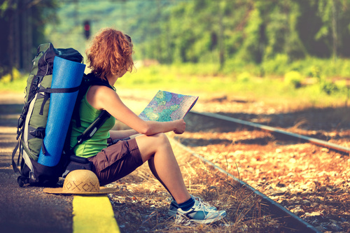 Holding map sitting on the roadside to rest backpackers Stock Photo