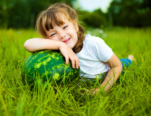 Little girl and watermelon on the grass Stock Photo