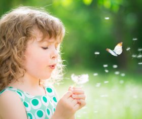 Little girl blowing dandelion flower Stock Photo