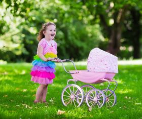 Little girl playing with newborn baby brother in summer park Stock Photo 03