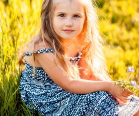 Little girl sitting on the grass Stock Photo