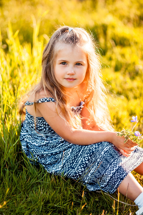 Little girl sitting on the grass Stock Photo