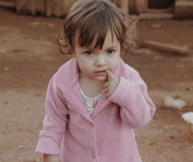 Little girl with finger in mouth Stock Photo