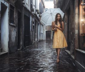 Outdoor hold up an umbrella yellow dress women Stock Photo