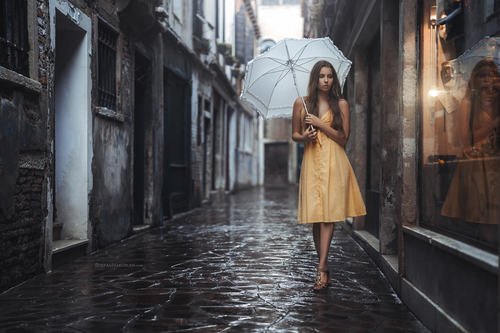 Outdoor hold up an umbrella yellow dress women Stock Photo