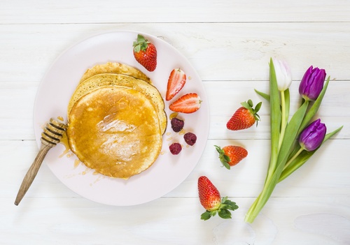 Pancakes on the table strawberries and tulips Stock Photo