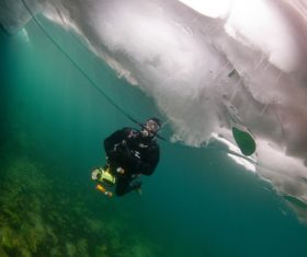 People diving under the ice Stock Photo