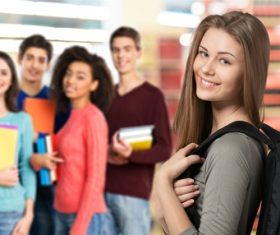 Smiling female college student and classmates Stock Photo