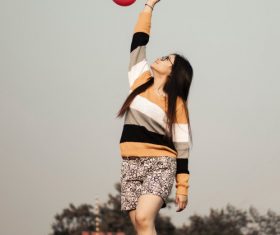 Standing high up woman putting balloons Stock Photo
