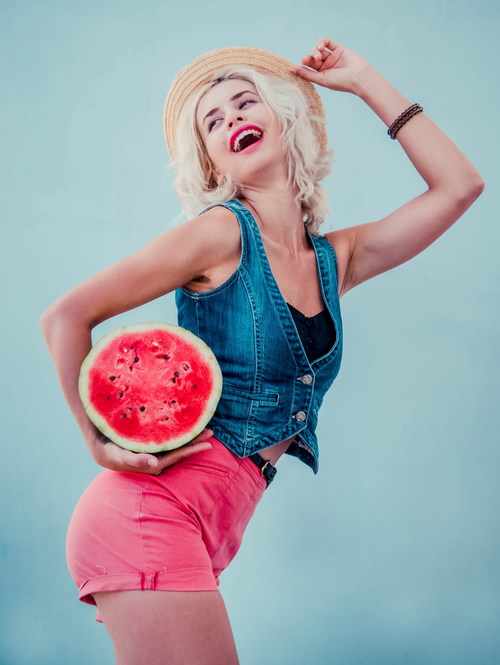 Stock Photo Woman holding half a watermelon posing