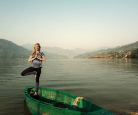 Stock Photo Woman standing on wooden boat with one leg