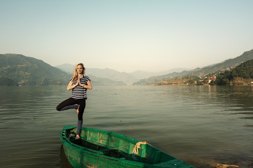 Stock Photo Woman standing on wooden boat with one leg