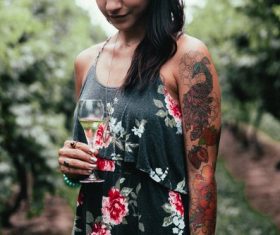 Tattooed woman tasting wine Stock Photo