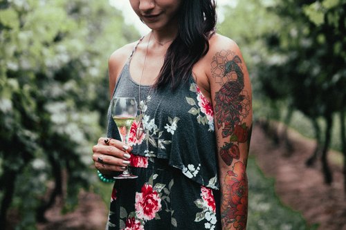 Tattooed woman tasting wine Stock Photo